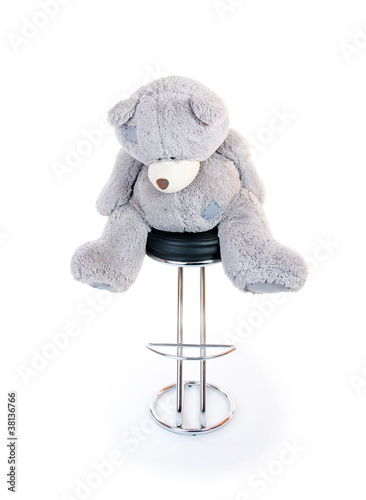 Photo: teddy bear sitting on a chair. isolated teddy bear sitting on a chair. isolated