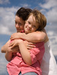 A girl embracing her sister with Down syndrome.