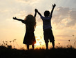 Silhouette, group of happy children playing on meadow, sunset