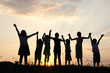 Silhouette, group of happy children playing on meadow