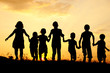 Silhouette, group of happy children playing on meadow