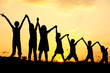 Silhouette, group of happy children playing on meadow,