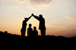 Silhouette, group of happy children playing on meadow,