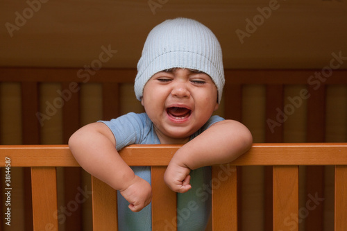 Foto: bambino che piange dentro la culla bambino che piange dentro la culla