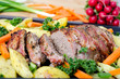 Hackbraten mit Schineknspeck umwickelt an Wurzelgemüse