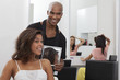 Hairdresser holding a mirror behind young woman