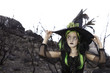 Pretty little witch holding her witch hat and looking away
