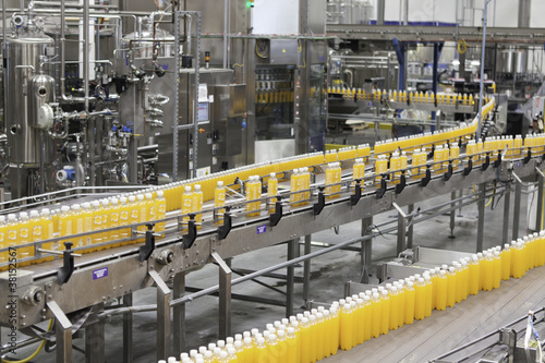 Photo: Juice bottles moving along the conveyor belt Juice bottles moving along the conveyor belt