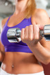 Sport - woman is exercising with barbell in gym