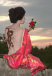 Geisha with dragon tattoo at sunset