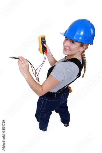 Foto: Female electrician with a voltmeter Female electrician with a voltmeter