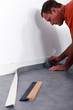 Man smoothing linoleum floor