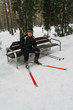 An elderly man sitting on a bench in cross country skiing