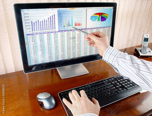 Photo: Analyzing financial data and charts on computer screen. Analyzing financial data and charts on computer screen.
