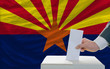 man voting on elections in front of flag US state flag of arizon