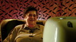 Happy retired senior woman watching tv