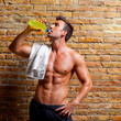 muscle shaped man at gym relaxed drinking