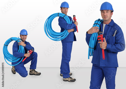 Photo: blue collar with hard hat carrying hose on his shoulder blue collar with hard hat carrying hose on his shoulder