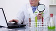 Video: Scientist with magnifying glass examines plants in test tubes Scientist with magnifying glass examines plants in test tubes