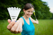 Pretty, young woman playing badminton in a city park