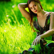 brunette sitting on green grass