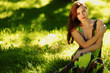 brunette sitting on green grass