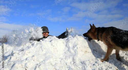 Photo: Boy and dog playing in snow Boy and dog playing in snow
