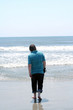 Teen Boy Walking Toward Surf With Closed Umbrella