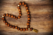 Photo: heart shape of rosary on wooden background heart shape of rosary on wooden background