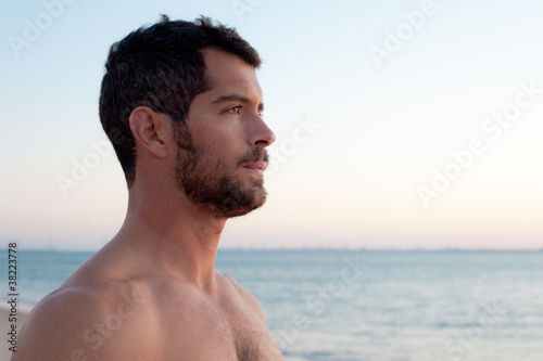 Photo: Handsome muscular man on the beach. Handsome muscular man on the beach.