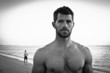 Muscular man on the beach. Black and white portrait.