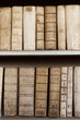 Covers of old ancient books monuscripts on shelves in bookcase