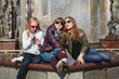 Teenage girls relaxing against a city fountain