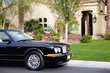 Luxurious car parked outside a mansion