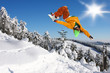 Snowboarder jumping against blue sky
