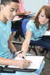 Teenage girl looking at her classmate's answers