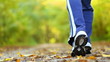 Woman walking cross country trail in autumn forest