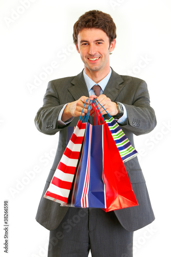 Photo: Portrait of smiling businessman with shopping bags Portrait of smiling businessman with shopping bags
