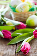 easter basket,eggs and tulips on wooden board
