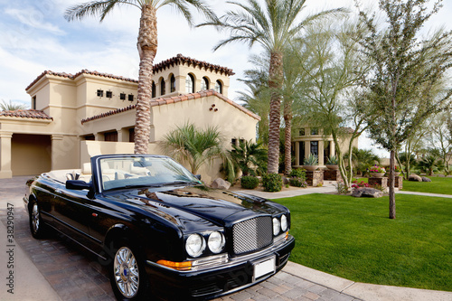 Photo: Black open roof car parked outside mansion house Black open roof car parked outside mansion house