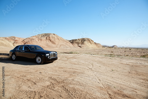 Photo: Rolls Royce car leaving trail of black oil behind on unpaved road Rolls Royce car leaving trail of black oil behind on unpaved road