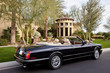 Convertible car parked outside mansion house
