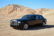 Rolls Royce car parked on unpaved road in front of mountains