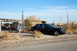 Rolls Royce parked on side of road near abandoned houses