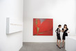 Two woman standing next to wall paintings