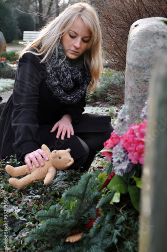 Foto: Frau trauert an Kindergrab Frau trauert an Kindergrab