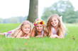 three girls smiling on a meadow