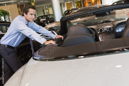 Photo: Car salesperson leaning on car Car salesperson leaning on car