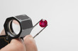 Close up of red gemstone in tweezers