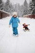 Photo: Little girl is pulling her snow scooter with a toy Little girl is pulling her snow scooter with a toy